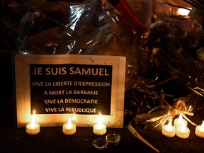 This photo, taken on Oct. 20 during the "Marche Blanche" in Conflans-Sainte-Honorine, northwest of Paris, shows a sign reading, "I am Samuel. Long live freedom of expression" in solidarity after a teacher was beheaded for showing pupils cartoons of the Prophet Muhammad. His murder in a Paris suburb on Oct. 16 shocked the country and brought back memories of a wave of Islamist violence in 2015. Samuel Paty, 47, was attacked on Oct. 16 on his way home from the junior high school where he taught by 18-year-old Chechen man Abdullakh Anzorov, who was shot dead by police. Following the attack, tens of thousands of people took part in rallies countrywide to honour Paty and defend freedom of expression. (Bertrand Guay/Getty Images)