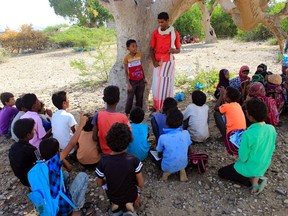 Displaced Yemeni children attend an open-air class in the shade of a tree in the district of Abs in the northern Hajjah province of Yemen on Wednesday. (Essa Ahmed/Getty Images))