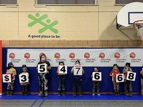 Children from the Boys and Girls Club of Kingston and Area show off the final fundraising total for the Kingston, Frontenac, Lennox and Addington United Way on Thursday.