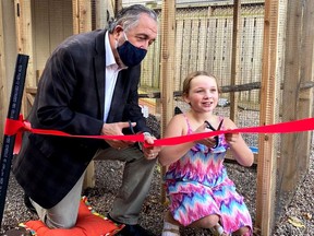 Councillor Dennis O'Connor and Axelle Bickerton cut the ribbon on the Bickerton chicken coop in Gananoque. The structure follows all legal guidelines and bylaws, and helps to usher in a new step in trying to create more stable food source in the town by allowing residents to produce their own eggs.  Photo by Dennis O'Connor