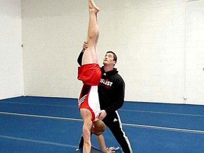 Former Canadian gymnast Alexander Jeltkov, now a coach at the Loyalist Gymnastics Club in Kingston, works with former senior level elite athlete and current coach Mattie Sergeant in a 2012 photo. Jeltkov was recently inducted into the Gymnastics Canada Hall of Fame. (Supplied Photo)