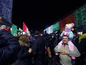 Jayme Shelley and his daughter Jane marvel at the lights in downtown Napanee as the town flipped the switch on the Big Bright Lights on Nov. 16, 2018. Due to the COVID-19 pandemic, the municipality will quietly turn on the downtown light show on Nov. 12 this year, forgoing the popular annual street party that usually draws thousands of spectators. (Meghan Balogh/The Whig-Standard)