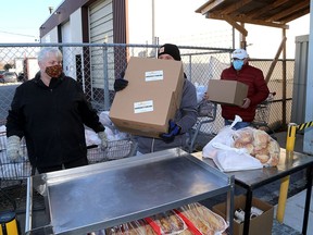 Volunteers at the Partners In Mission Food Bank prepare food bags for pickup at their Hickson Avenue location on Wednesday.