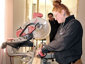 Sarah Vanzella measures a 2x4 before cutting it as her employer, Christopher Gauthier, watches.
PJ Wilson/The Nugget