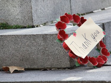 A child's homemade wreath of poppies preciously set upon the stone base of the cenotaph in Pembroke sums up Remembrance Day. Anthony Dixon