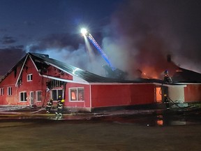 As the sun went down Monday evening, members of the Pembroke Fire Department continued to battle the blaze at the former Red Bargain Barn building in west end Pembroke, using the aerial truck to attack the flames from above. It is believed the fire started in the attic. Firefighters are expected to remain on the scene throughout the night.