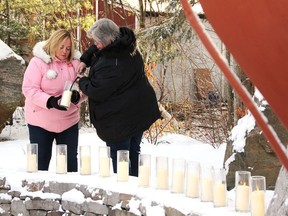 During the 2019 memorial, Bev Ritza (right) from the Women's Sexual Assault Centre of Renfrew County, lights candles in memory of the 14 women who were murdered at Montreal's Ecole Polytechnique on Dec. 6, 1989. Helping her is Renate Ashick. TINA PEPLINSKIE / PEMBROKE OBSERVER AND NEWS