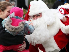 One-year-old Ashlynne Brooks, held by Barb Mitchell, both of Sarnia, shows her decorated cookie to 'Santa Claus' at Christmas on the Farm in Sarnia in December, 2019. The event is going mostly virtual this year amid the novel coronavirus pandemic. Tyler Kula/The Observer