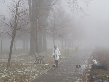 A woman goes for a walk with her dogs as a thick blanket of fog covers the landscape in Sudbury, Ont. on Wednesday November 4, 2020. John Lappa/Sudbury Star/Postmedia Network