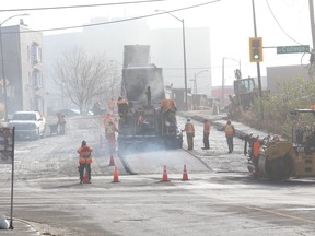 Steam rises off asphalt while workers pave Frood Road near College Street in Sudbury, Ont. on Wednesday November 4, 2020.