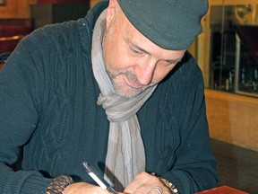 Rod Carley autographs a copy of his second novel, Kinmount.