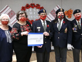 Sandra Sharko, left, president of the Ukrainian Seniors' Centre, and Roma Shewciw, poppy mask maker, present a $1,610 cheque to Lockerby Legion Branch 564 members Raymond Young, centre, first vice-president, president Jennifer Huard and first vice-president Eddie Thompson at the Ukrainian Seniors' Centre in Sudbury, Ont. on Monday November 9, 2020. The funds were raised by the centre from the sale of poppy masks.