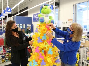 Lynne Ethier, left, manager of fundraising and community engagement for Our Children, Our Future, and Cheryl Spencer, of Toys R Us, decorate a tree with paper ornaments featuring children's names at the launch of the annual Tree of Dreams Toy Drive in Sudbury, Ont., on Thursday November 12, 2020. Our Children, Our Future and Toys R Us in Sudbury are partnering up to help ensure that less fortunate children in Greater Sudbury will receive a gift on Christmas Day. People can support the toy drive by choosing an ornament from the Tree of Dreams, purchase a gift for that child and a Toys R Us associate will place the ornament and the unwrapped gift in a bag.