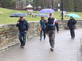 A small group of people go for a walk in the rain at Bell Park in Sudbury, Ont. on Friday November 13, 2020. Environment Canada said Greater Sudbury can expect a mix of sun and cloud with a high of 4 C on Saturday.