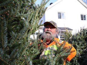 Mike Peters checks over a Christmas tree located on his property on Balsam Street in Copper Cliff, Ont. on Wednesday November 18, 2020. Peters is hoping to sell nearly 300 trees as well as a number of wreaths, as part of a fundraiser for Copper Cliff Scouting. Starting Nov. 21, people will be able to purchase the trees and wreaths. The tree lot will be open from 9 a.m. to 9 p.m. on the weekend, and noon to 9 p.m. during the week.