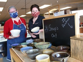Owners Rachelle Rocha, left, and Laurie Pennell, of Seasons Pharmacy and Culinaria, display bowls created by the Sudbury Basin Potters at their business on Lorne Street in Sudbury, Ont. on Friday November 20, 2020. "Soup's On Reimagined" - Lunch with Sudbury Basin Potters for the Blue Door Soup Kitchen, will be held every day from Nov. 20-30 at Seasons Pharmacy and Culinaria, except on Sundays. All bowls will be priced at $12, with all money raised donated to the Blue Door Soup Kitchen.