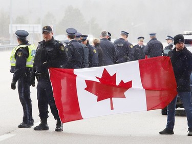 Local Ontario Provincial Police officers gathered at the overpass near Estaire to show their respect for a procession featuring OPP Const. Marc Hovingh's body on Monday November 23, 2020. John Lappa/Sudbury Star/Postmedia Network