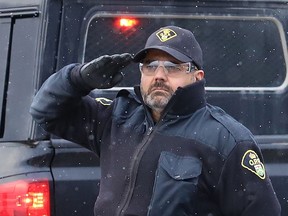 Local Ontario Provincial Police officers gathered at the overpass near Estaire to show their respect for a procession featuring OPP Const. Marc Hovingh's body on Monday November 23, 2020.