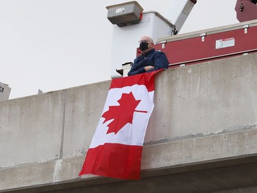 Community members, Ontario Provincial Police officers, first responders and hydro workers gathered at the overpass near Estaire to show their respect for a procession featuring OPP Const. Marc Hovingh's body on Monday November 23, 2020. John Lappa/Sudbury Star/Postmedia Network