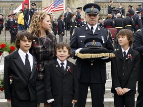 Heather Pham, wife of OPP Const. Vu Pham with her three sons, looks at her husbands headdress during the Canadian Police and Peace Officer's Memorial Sunday September 26, 2010.