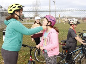 Beth Jones helps her daughter Nadia, 9, strap on a helmet before they head out cycling at White Waterfront Conservation Area on what was an unseasonably warm day on Monday. They were accompanied by Nadia's siblings Sonya, 13, and Neil, 9.

RICHA BHOSALE/The Daily Press