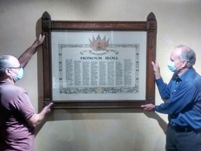 Mike Baker, right, Elgin County Museum curator, and Bob Osthoff, exhibition installer, hang the honour roll of members of St. Thomas and Elgin's 91st Battalion who were killed in action during the First World War. The 91st trained 940 men for overseas service; 172 didn't return. In all, an estimated 2,400 residents of St. Thomas and Elgin volunteered for the war. The honour roll dates to the 1930s and the 91st Battalion chapel at Trinity Anglican Church. With the closure of the church earlier this year, the chapel altar, the honour roll and other artifacts have been moved to the museum.Eric Bunnell/Special to the Times Journal