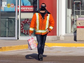 A man carrying food items exits a Pembina Highway store in Winnipeg on Mon., Nov. 23, 2020. Kevin King/Winnipeg Sun/Postmedia Network