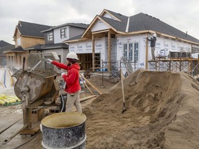 Matthew Senior mixes mortar as bricklayers work on an exterior wall of a home in Ilderton. Construction is among the few parts of Ontario's rural economy that haven't been hit by COVID-19's second wave. Mike Hensen