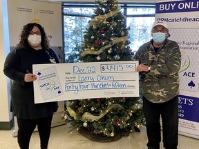 Pembroke Regional Hospital Foundation community fundraising specialist, left, Leigh Costello, presents PRHF Catch the Ace Week 23 winner Larry Okum with his winnings just before Christmas. Submitted photo