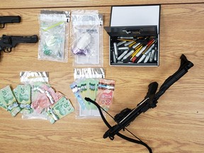 Three people face multiple charges following a two-vehicle collision, Sunday, on Highway 17 in Bonfield. Ontario Provincial Police seized cash, suspected opioids, imitation handguns and what appears to be a crossbow. Ontario Provincial Police Photo
