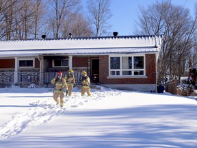 North Bay firefighters step out of a home on Francis Street, Wednesday afternoon, following a fire. Michael Lee/The Nugget