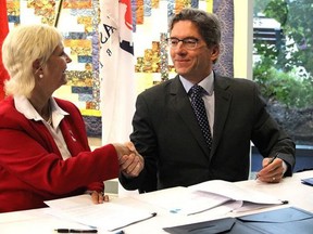 Fort Saskatchewan Mayor Gale Katchur, left, shakes hands with Strathcona County Mayor Rod Frank in 2018, after signing the Alliance Exploration Agreement, a joint commitment to collaboration. Postmedia File