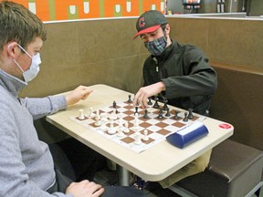 Evan Kilroy makes a chess move while Adam Wallace watches. The North Bay Chess Club is continuing to meet and play games, although members admit more games are being played online due to the COVID-19 pandemic.
PJ Wilson/The Nugget