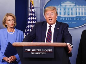 U.S. President Donald Trump addresses a coronavirus response briefing as Education Secretary Betsy DeVos and Agriculture Secretary Sonny Perdue listen at the White House in Washington, U.S., on March 27, 2020. 
(REUTERS/Jonathan Ernst/ fie photo)