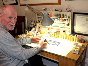 George Sims paints a chess piece he recently cast that will be added to the 60 chess sets the Chatham man has collected over the years. Ellwood Shreve/Postmedia Network