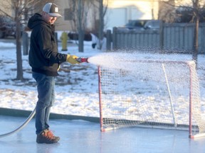 O’Brien Lake resident Garett Dika floods the outdoor rink at Monkman Park on Wednesday morning. Dika, along with three other adults in his neighbourhood, built the rink. The novice ice man talked about the challenges in building the rink and the satisfaction upon completion.