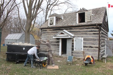 Brennen Guest, left, and Dedrick Wubs, with Schouten Excavating prepare the log cabin in Sarnia's Canatara Park for its move to the Lambton Heritage Museum in Lambton Shores. A volunteer group is raising money to have the cabin restored at the museum.