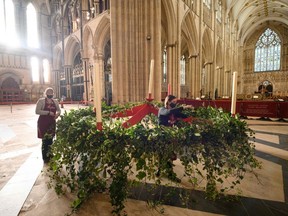 Flower arrangers Mandy Barker, left, and Elizabeth Freeman put the finishing touches to York Minster's advent wreath, thought to be one of the biggest in the country, before it is lifted into place below the Central Tower for the first time since 2017, in York, northern England, on Nov. 27, 2020. The wreath, which has been made by the cathedral's volunteer flower arrangers using ivy and holly sourced mainly from the minster's gardens, will hold five candles which are gradually lit each Sunday during Advent in the countdown to Christmas Day. (Oli Scarff/AFP via Getty Images)