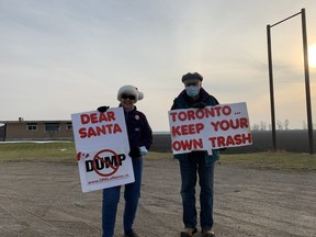 Bonnie and Neil Dennison of South-West Oxford sign wave against the proposed Walker landfill on Friday, Dec. 11, 2020. (Kathleen Saylors/Woodstock Sentinel-Review)