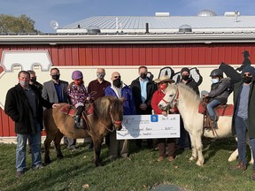 The 100+ Men Who Care Chatham-Kent presented a $8,600 cheque to TJ Stables for its Acceptional Riders therapeutic riding program on Dec. 11. Shown standing here, from left to right, are Jon Eenink, David Dawson, Chatham-Kent Mayor Darrin Canniff, Chris Summerfield, Ed Carney, Chris Appleton, TJ Stables owner Terry Jenkins, Dane Appleton and Daryn Trainor. On the horses are Margaret, left, and Trevon. (Handout/Postmedia Network)