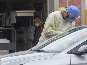 A medical professional makes an assessment at the COVID-19 assessment centre at Carling Heights Optimist Community Centre in Londo in October. Derek Ruttan/Postmedia Network