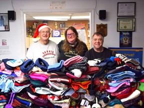 Terry Lilley, Brooke Lilley-Pierce and Matthew Churchill (left to right) stand in front of a pile of donated winter wear, collected during the annual Penny M. Lilley Memorial Wooly Toss. Handout/Sarnia This Week