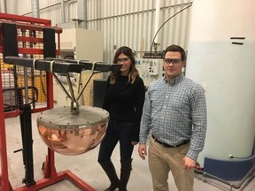 NWMO corrosion scientists Dr. Mehran Behazin and Dr. Jeffrey Binns pose with a section of a prototype of the copper-coated used nuclear fuel container. SUBMITTED