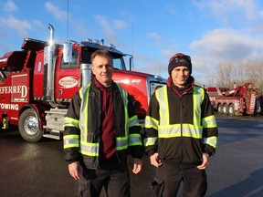 Gary Vandenheuvel, and his son Collin Vandenheuvel, stand next to a new vehicle added to the fleet at Preferred Towing in Sarnia, and featured with them on the reality television series, Heavy Rescue: 401.