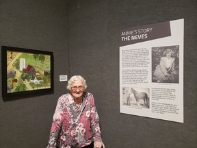 Ninety-four-year-old folk artist Annie McLaughlin stands in front of one of her colourful paintings, The Homeplace, which is on display as part of her exhibition Memories of Rural Life at the Lambton Heritage Museum until April 2021. Handout/Sarnia This Week