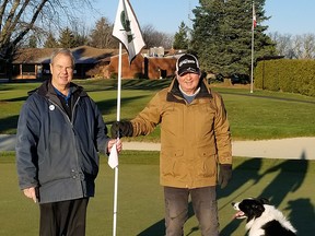 John Dengel, head golf pro and manager at Maple City Country Club, left, and John Pickard, greens superintendent, pull out the pins on the last day of the season, as Pickard's dog Ace sits by. Dengel and Pickard are both retiring after 44 years and 41 years, respectively. (Handout/Postmedia Network)