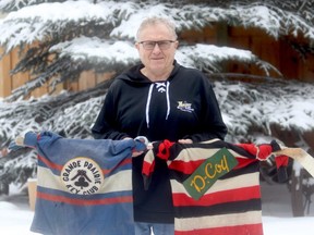 Grande Prairie Hockey Legends chairman Stan Neufeld holds two jersey’s from the legends memorabilia collection. The hockey history group is in fundraising mode, trying to raise money for a new display case.  The blue sweater is from the Grande Prairie Key Club, circa 1947 and the striped sweater is the Grande Prairie DCoy, circa 1947-48..