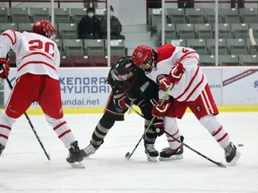 Kenora Thistles forward Nickolas Fagnilli battles with Fort Frances Laker forward Nick Hahkala as Thistles defenceman Jace Dittaro looks on during Superior International Junior Hockey League action at Thistle Arena on Sunday, Dec. 20.