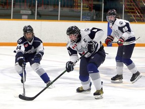 Miguel Renaud (8) of Team White plays the puck as Cowan Billard (44) of Team Navy defends, while Jet Bertrand (98) of Team White looks on during a Sudbury Wolves U16 AAA instra-squad game at Gerry McCrory Countryside Sports Complex in Sudbury, Ontario on Tuesday, December 22, 2020.