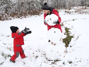 Kamma Montague and her son, Kaynnan, 2, make a snowman at Fielding Memorial Park in Greater Sudbury. John Lappa/Sudbury Star/Postmedia Network